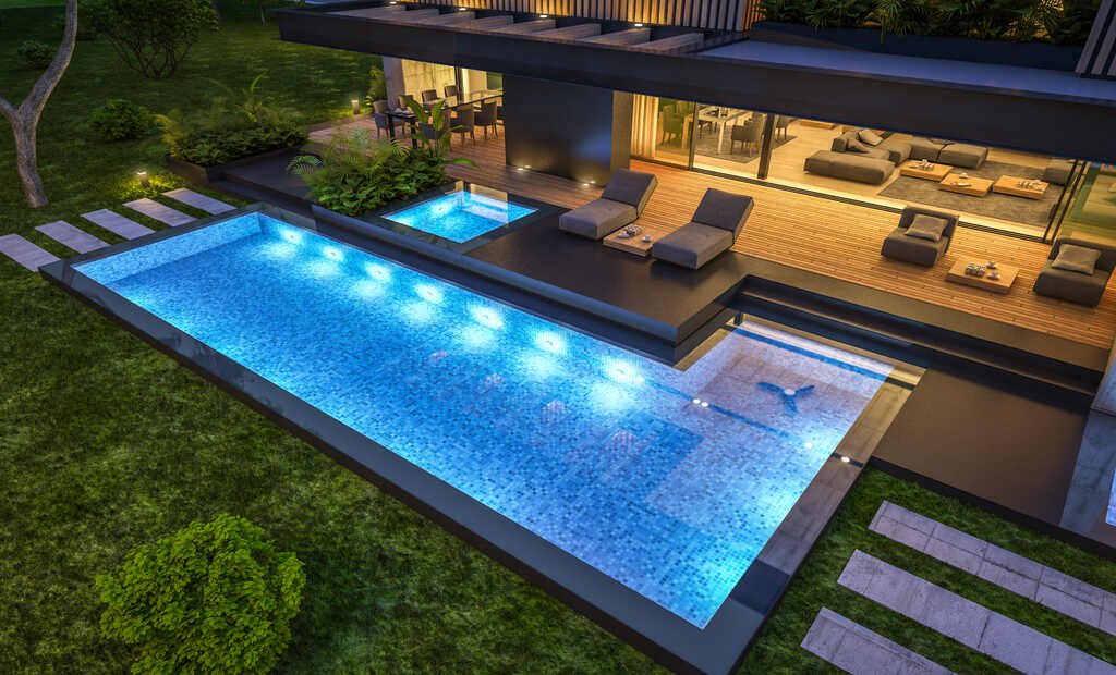 Imagem de uma luxuosa casa moderna com uma piscina iluminada e área de jardim, perfeita para relaxamento e entretenimento.