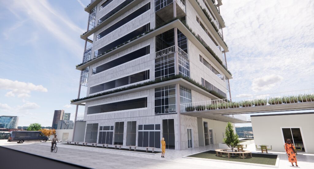 Imagem de um moderno edifício com várias janelas e uma área externa com mesas e árvores, ideal para ambientes corporativos.