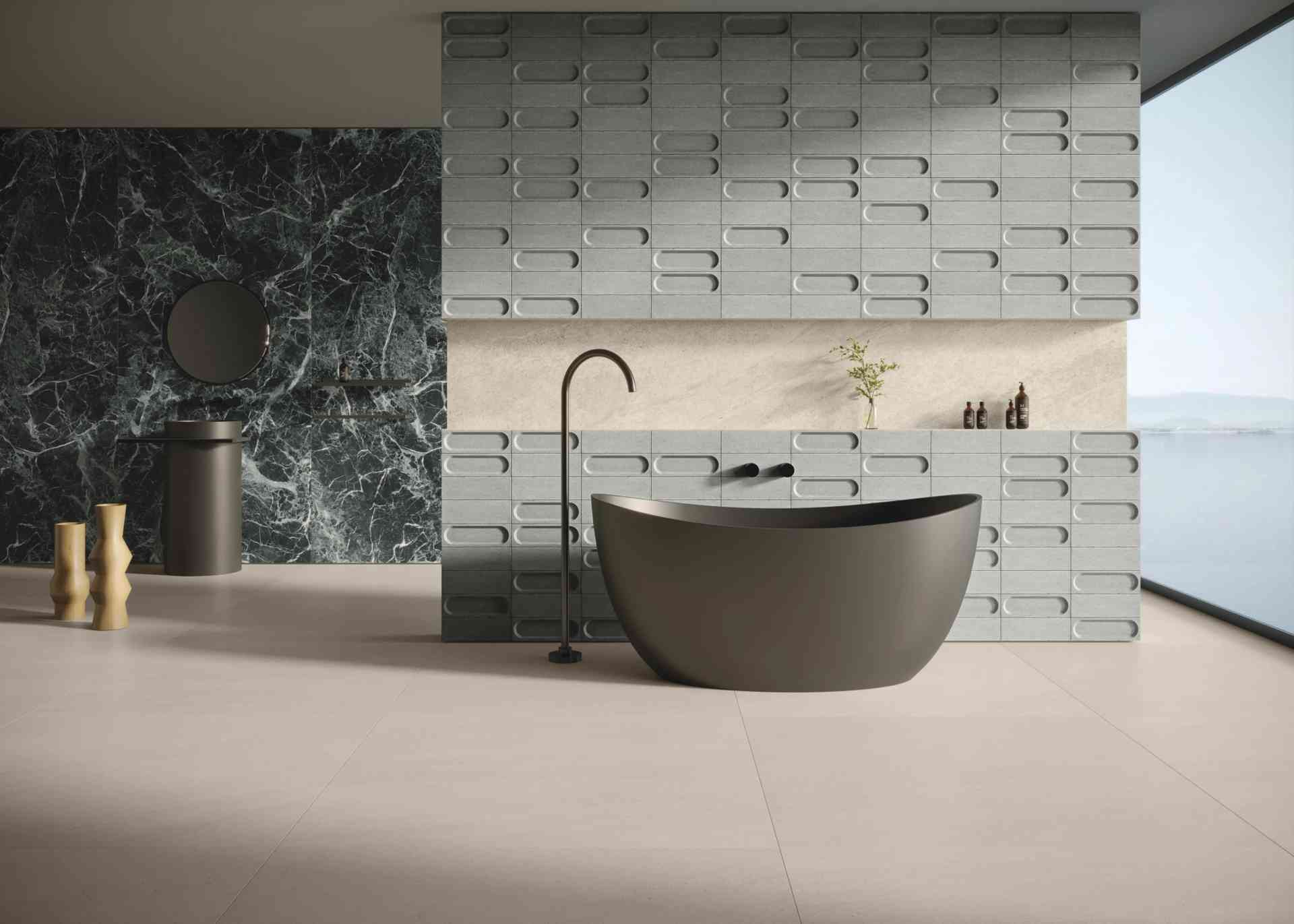 Banheira moderna em banheiro com design minimalista, azulejos cinza e detalhe de pedra na parede, iluminação natural e vista para o exterior.