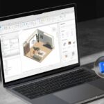 Notebook aberto em uma mesa mostrando o Revit aberto.
