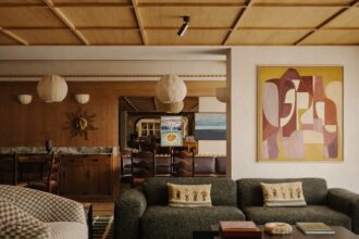 Decoração moderna e aconchegante para o ano de 2026 em uma sala de estar com móveis elegantes, iluminação suave e uma obra de arte abstrata na parede.