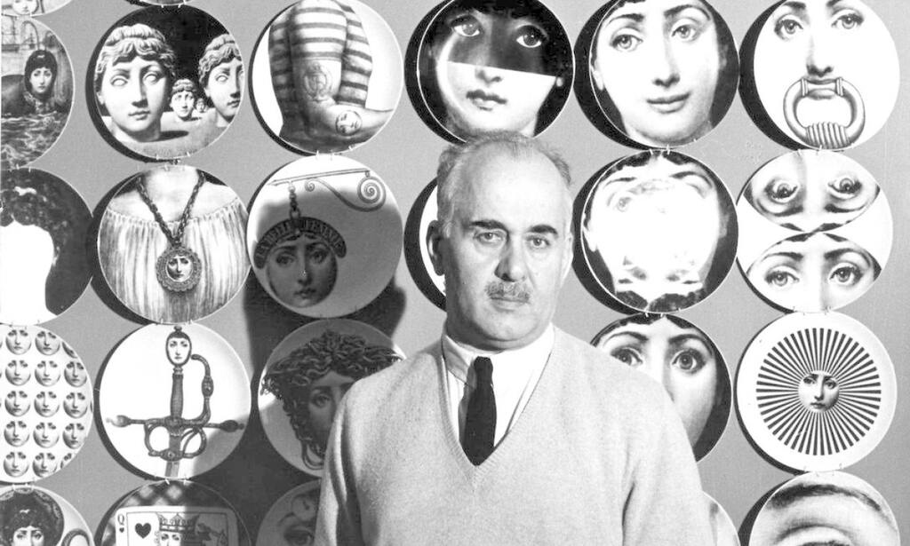 Piero Fornasetti em preto e branco, ladeado por sua icônica coleção de pratos decorativos com rostos e motivos surreais.
