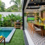 Área externa com piscina decorada para a copa do mundo 2026, com bandeirinhas do Brasil, luzinhas amarelas e mesa em verde e amarelo.